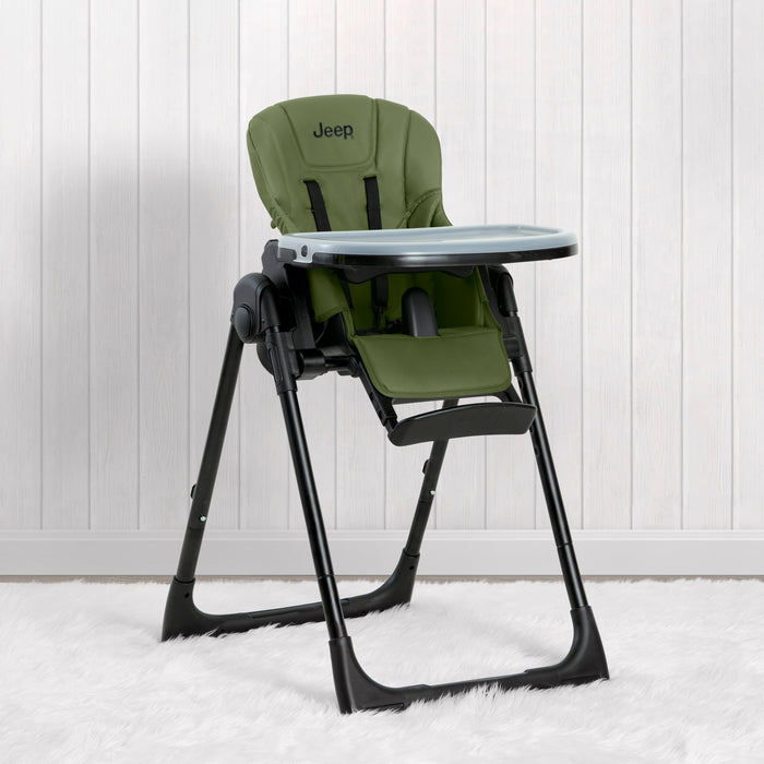 A black Jeep high chair for babies and toddlers with a green seat cushion, adjustable footrest, and metal legs, displayed against a white background. 1-Jeep Classic Convertible 2-in-1 High Chair for Babies and Toddlers with Adjustable Height, Recline & Footrest