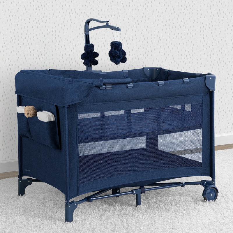 Navy blue baby crib with mobile on a white background
