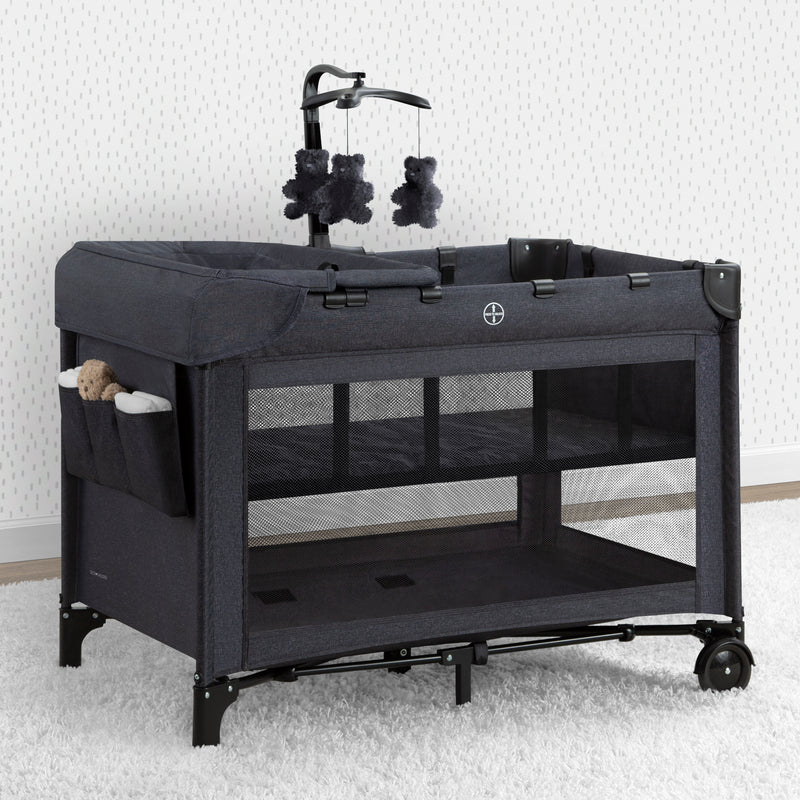 Black baby playpen with toys on a white background