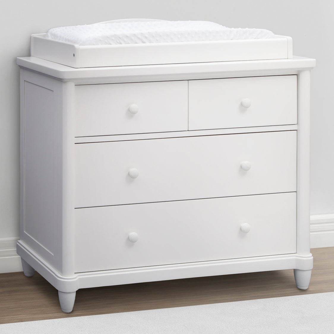 A gray Belmont 4 Drawer Dresser with a removable changing top topper, featuring safety stops on the drawers.