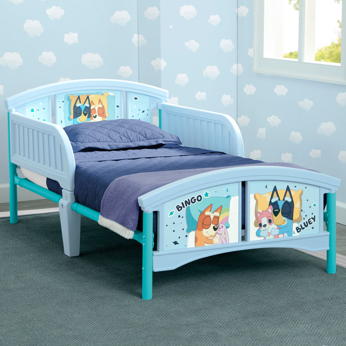 Children's bed with cartoon character panels in a room with polka dot wallpaper. 3-Bluey Plastic Toddler Bed