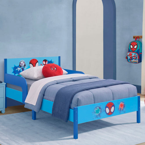 A children's bed with a bright blue frame decorated with Spider-Man character graphics, styled with blue bedding, a red round pillow, and a Spider-Man backpack hanging on the wall in a matching blue bedroom.
