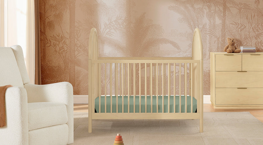 Nursery room with wooden crib, chair, and dresser. 1-Cannon Collection