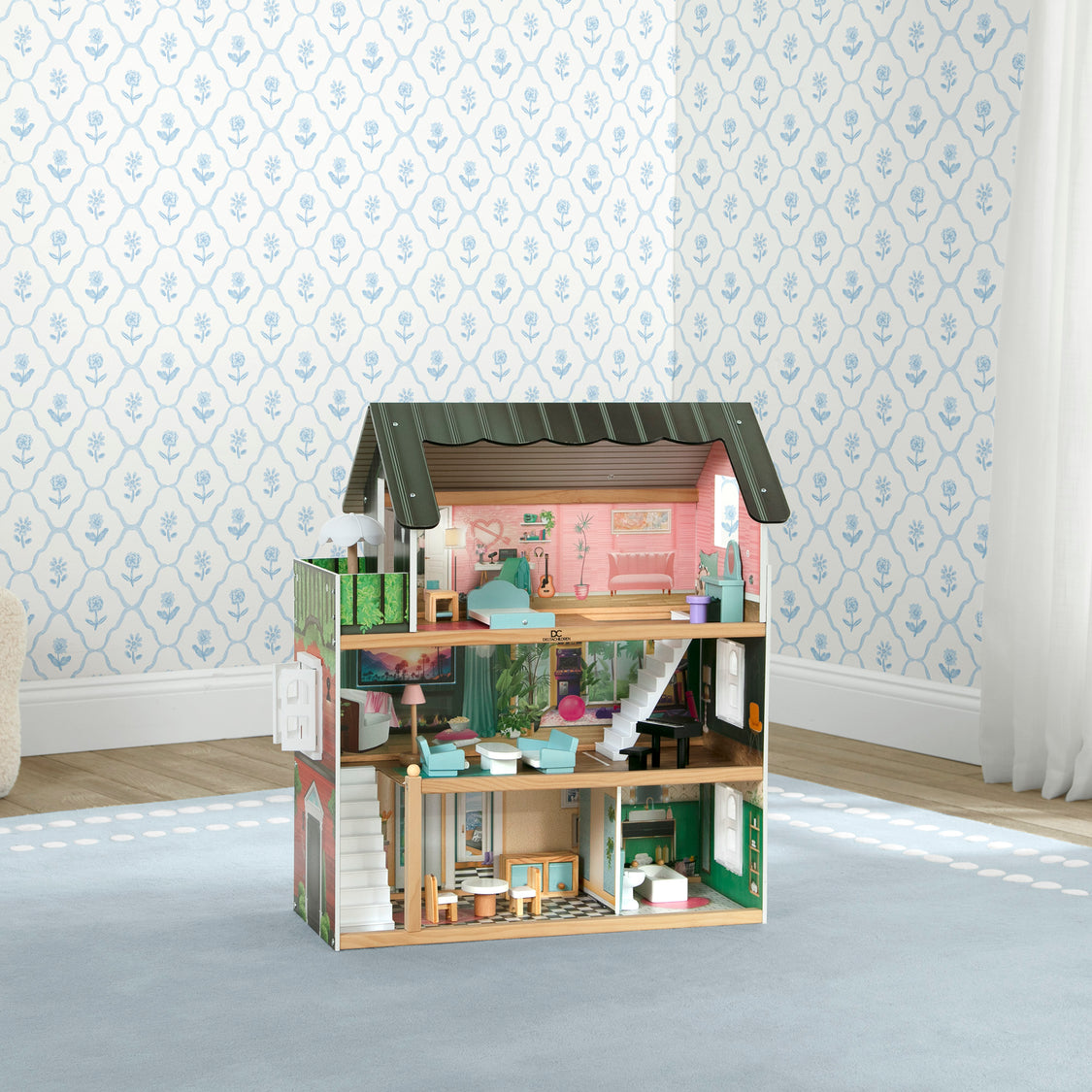 Wooden dollhouse with detailed interior in a room with patterned wallpaper