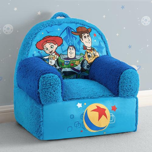 A plush children's armchair styled like a blue couch, featuring characters from Toy Story on the backrest and a large Ballpark graphic on the front, set against a light gray wall with white stars.