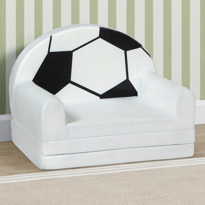 Children's chair designed like a soccer ball against a striped wall. 3-Cozee Soccer Ball Figural Flip-Out 2-in-1 Convertible Chair to Lounger