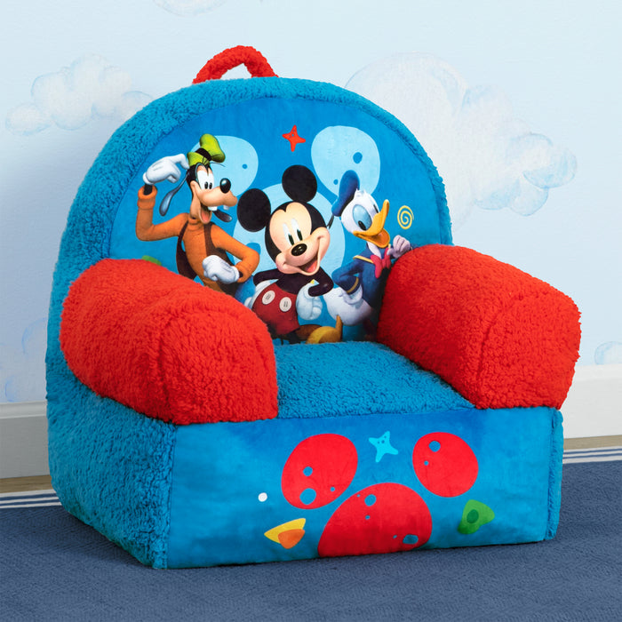 A plush Mickey Mouse themed Cozee Buddy Chair with blue and red colors, featuring character graphics and a satchel handle. 3-Mickey Mouse Cozee Buddy Chair