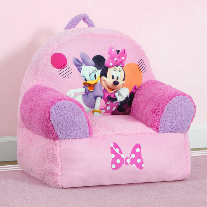 A pink foam chair with Minnie Mouse graphics, featuring a handle and a bow with polka dots. 2-Minnie Mouse Cozee Buddy Chair