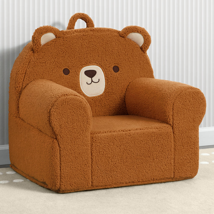 A plush brown teddy bear chair with a handle, designed for children, with a slipcover featuring a bear face. 1-Deluxe Cozee Teddy Bear Chair