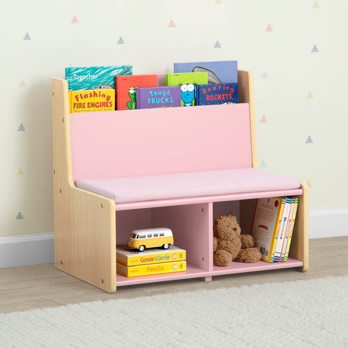 Children's bookshelf with pink top and storage compartments, filled with books and toys, against a light-colored wall.