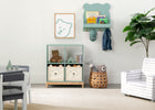 Children's room with a bookshelf, teddy bear, and decorative items. 17-Brannan Bear Bookcase with Bins