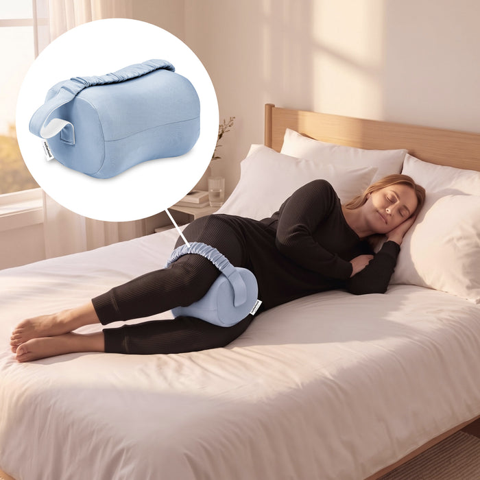 A woman lies on a bed using a light blue pelvic floor support pillow, with a circular inset showing the pillow alone. The room has white bedding, a wooden headboard, and soft natural light. 3-Adjustable Knee Pillow