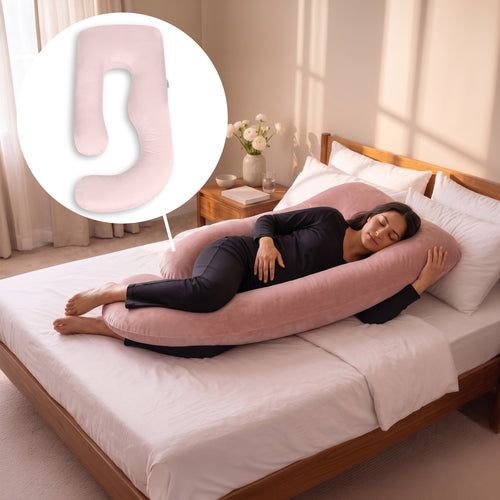 A woman lies on a bed using a large pink U-shaped maternity pillow, with a circular inset showing a close-up of the pillow's shape. The room has warm sunlight, white bedding, and a wooden headboard.