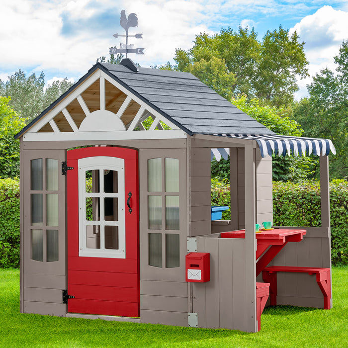 Children's playhouse with red door and gray roof in a garden setting 2-Cedar Springs Outdoor Playhouse