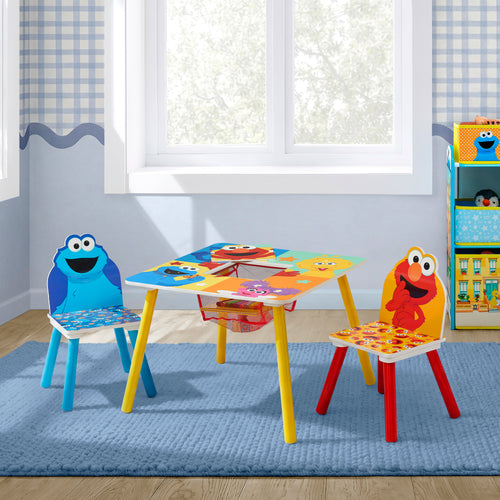 A children's table and two chairs with colorful Sesame Street character graphics, shown in a styled room with a window, rug, and shelving.