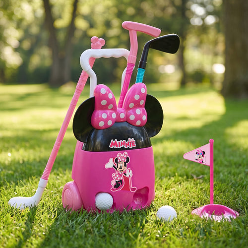 A pink Minnie Mouse golf ball carrier set with pink and white golf clubs, a pink flag, and golf balls on a grassy lawn in a sunny park.