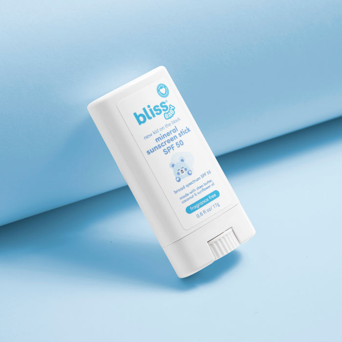 A white stick of Bliss Newborn Sunscreen Stick SPF 30, angled diagonally on a light blue background. 0-New Kid on the Block Mineral Sunscreen Stick - SPF 50