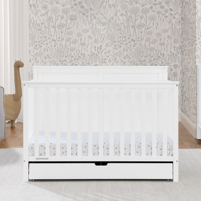 White crib with a floral patterned wall in the background 60-Logan 6-in-1 Convertible Crib with Underdrawer