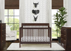 Nursery room with a wooden crib, dresser, and decorative wall art. 23-Remy 6-in-1 Convertible Crib