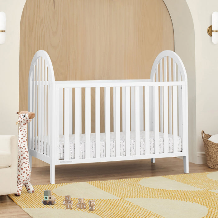White crib in a nursery with toys on the floor 1-Milano 4-in-1 Convertible Crib