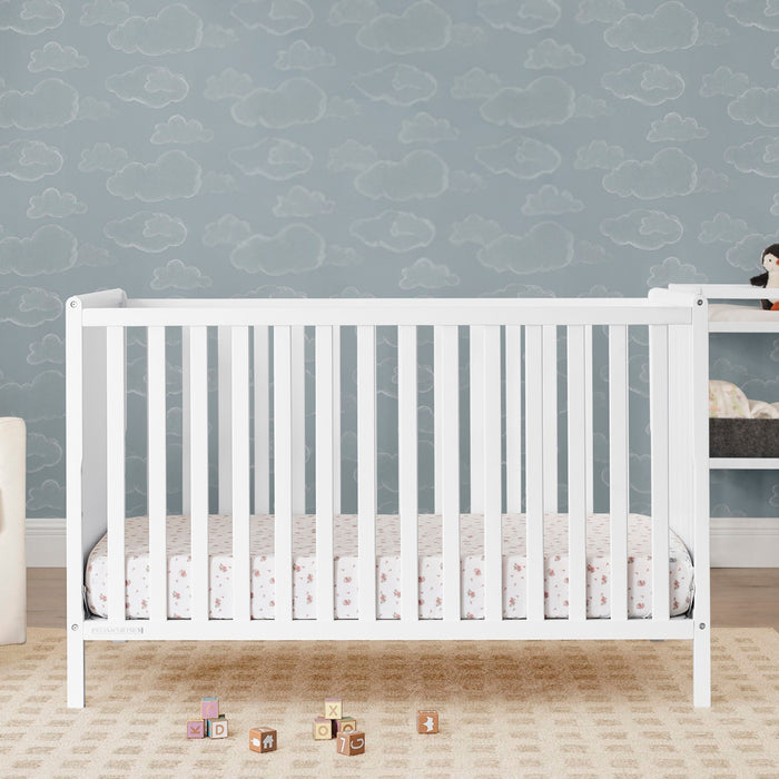 White crib with patterned bedding against a blue wall with cloud design 0-Ruby 6-in-1 Convertible Crib & Changing Table 2-Piece Set