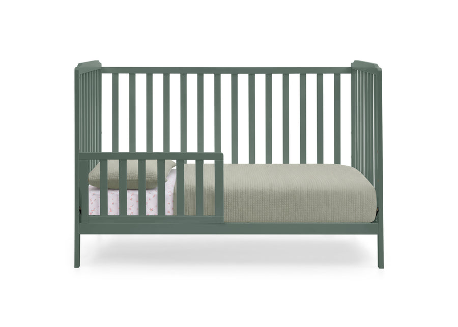 A sage green convertible crib with vertical slats, shown with a mattress and light-colored bedding on a solid white background. 23-Emmie 4-in-1 Convertible Crib