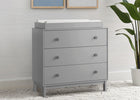 Gray dresser with a changing table top in a room with a plant and framed pictures on the wall. 9-babyGap Legacy 3 Drawer Dresser with Interlocking Drawers