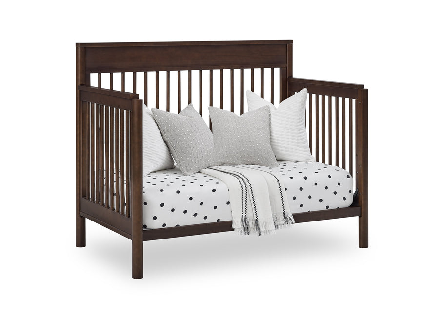 Wooden crib with white bedding and pillows on a white background 12-Remy 6-in-1 Convertible Crib