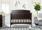 A dark brown wooden convertible crib in a styled nursery room, featuring giraffe wall art, a dresser, a gray armchair, and a patterned rug. 19-Archer 4-in-1 Convertible Crib