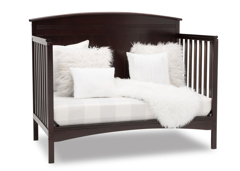 Dark wood crib with white bedding and fluffy pillows on a white background 20-Archer 4-in-1 Convertible Crib