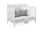 White crib with gray pillows and a polka dot blanket on a white background 22-Richmond 6-in-1 Convertible Baby Crib