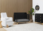 Nursery room with black crib, white armchair, and wooden dresser. 11-babyGap Oxford 6-in-1 Convertible Crib
