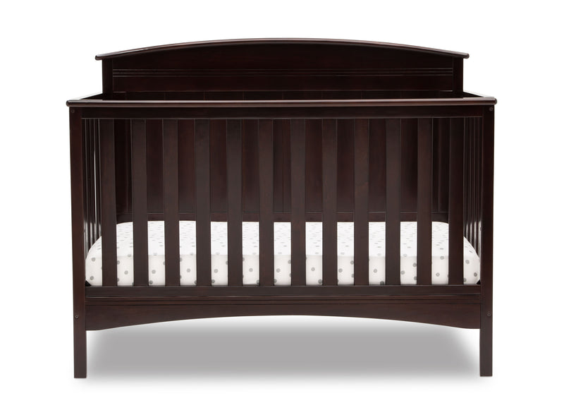 A dark brown wooden convertible crib with vertical slats and a curved headboard, shown with a white mattress inside, isolated on a white background. 23-Archer 4-in-1 Convertible Crib