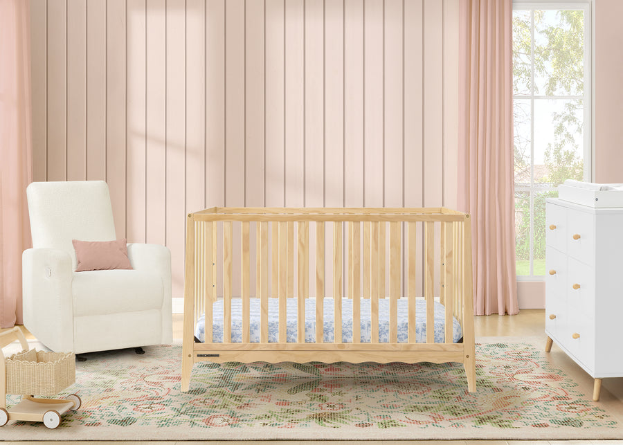 Nursery room with wooden crib, white chair, and dresser against a striped wall. 31-Lulu 5-in-1 Convertible Crib