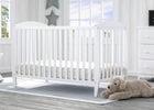White crib in a bright nursery with a teddy bear on the floor. 23-Taylor 4-in-1 Convertible Crib