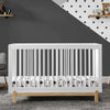 White crib in a room with a dark gray wall and polka dot pattern. 8-Poppy 4-in-1 Convertible Crib