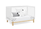 White crib with wooden legs and bedding on a white background 14-Poppy 4-in-1 Convertible Crib