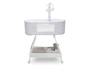 Side view of the baby bassinet with canopy, star and moon toys, and plush teddy bear inside, on a white frame.