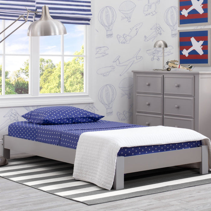 A Platform Twin Bed with a grey headboard and white and blue bedding in a child's room with decorative wall decals. 2-Platform Twin Bed